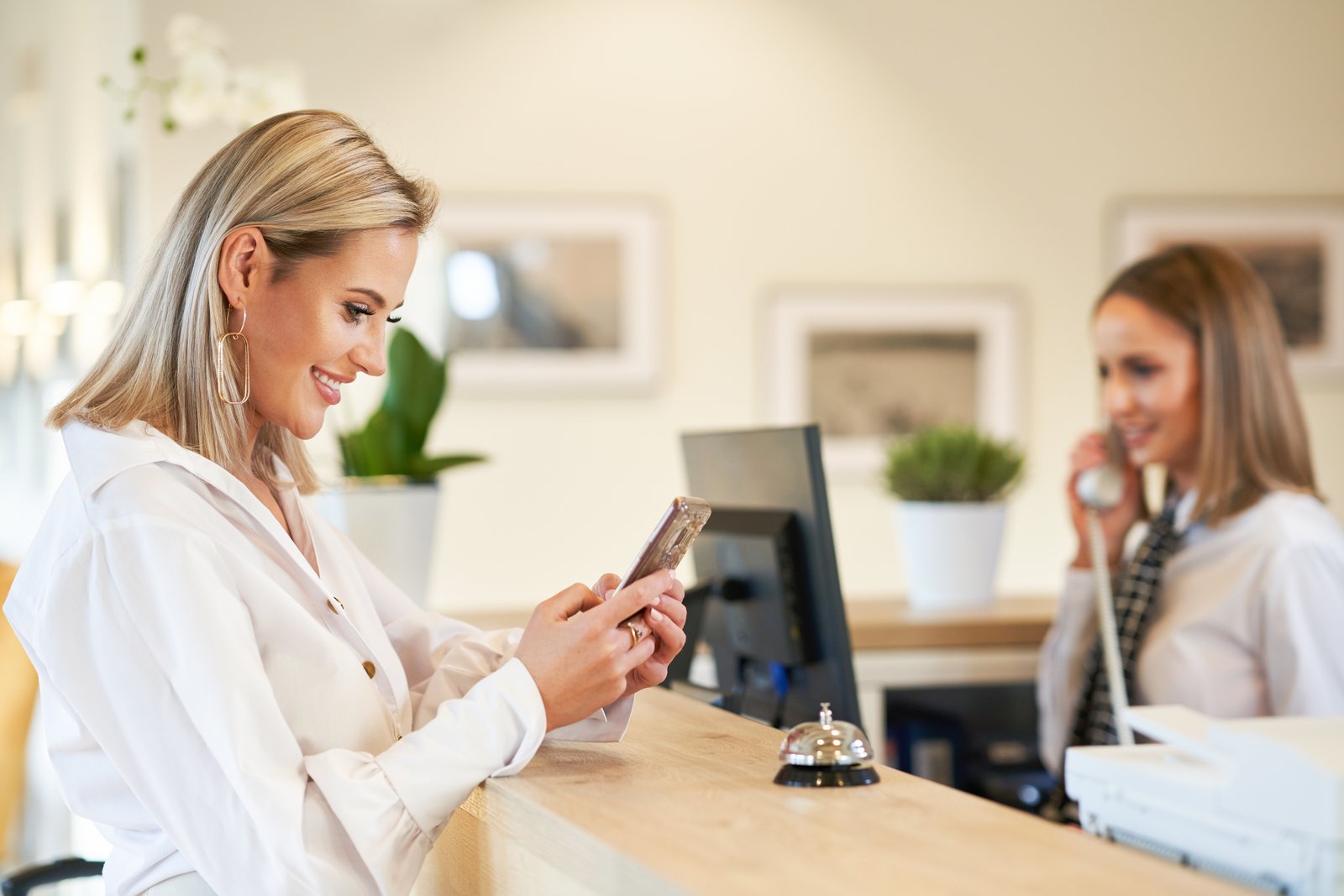 Guest checking in at hotel reception with smartphone